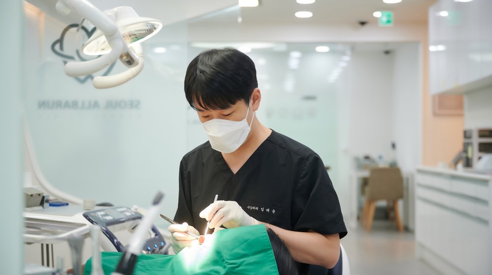 치료용 조명 아래에서 뿌리 안을 정리하는 신경치료 장면