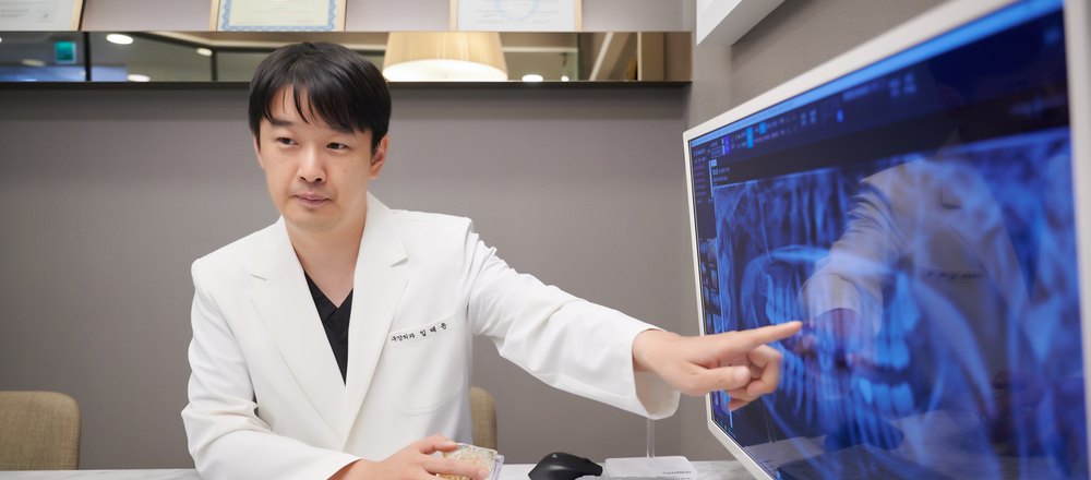 상담실에서 파노라마 화면을 짚어 가며 계획을 설명하는 임태윤 대표원장